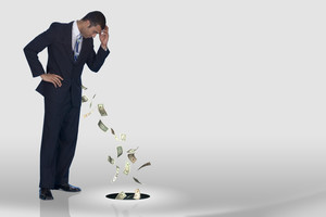 A businessman losing his money down the drain
